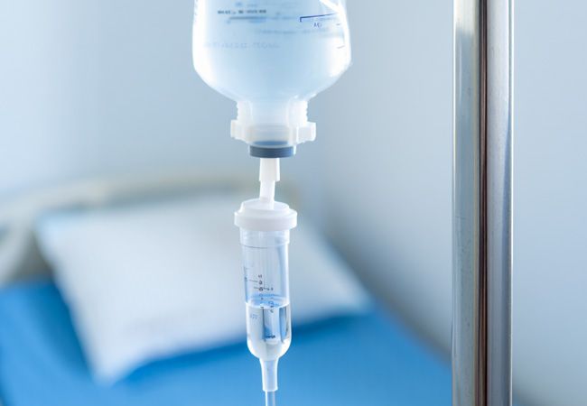 Инфузионный мешок с прозрачной жидкостью и градуировкой висит на металлической стойке